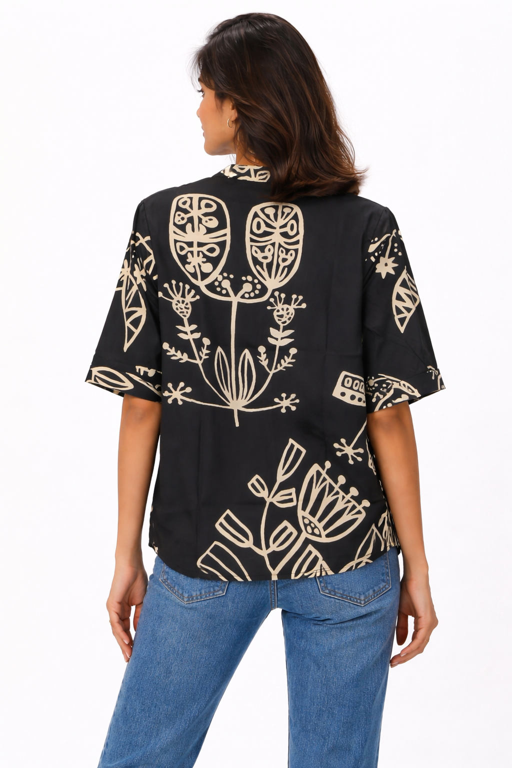 Top featuring a V-neckline and short sleeves. Designed with a relaxed silhouette and finished with a contrasting all-over abstract print