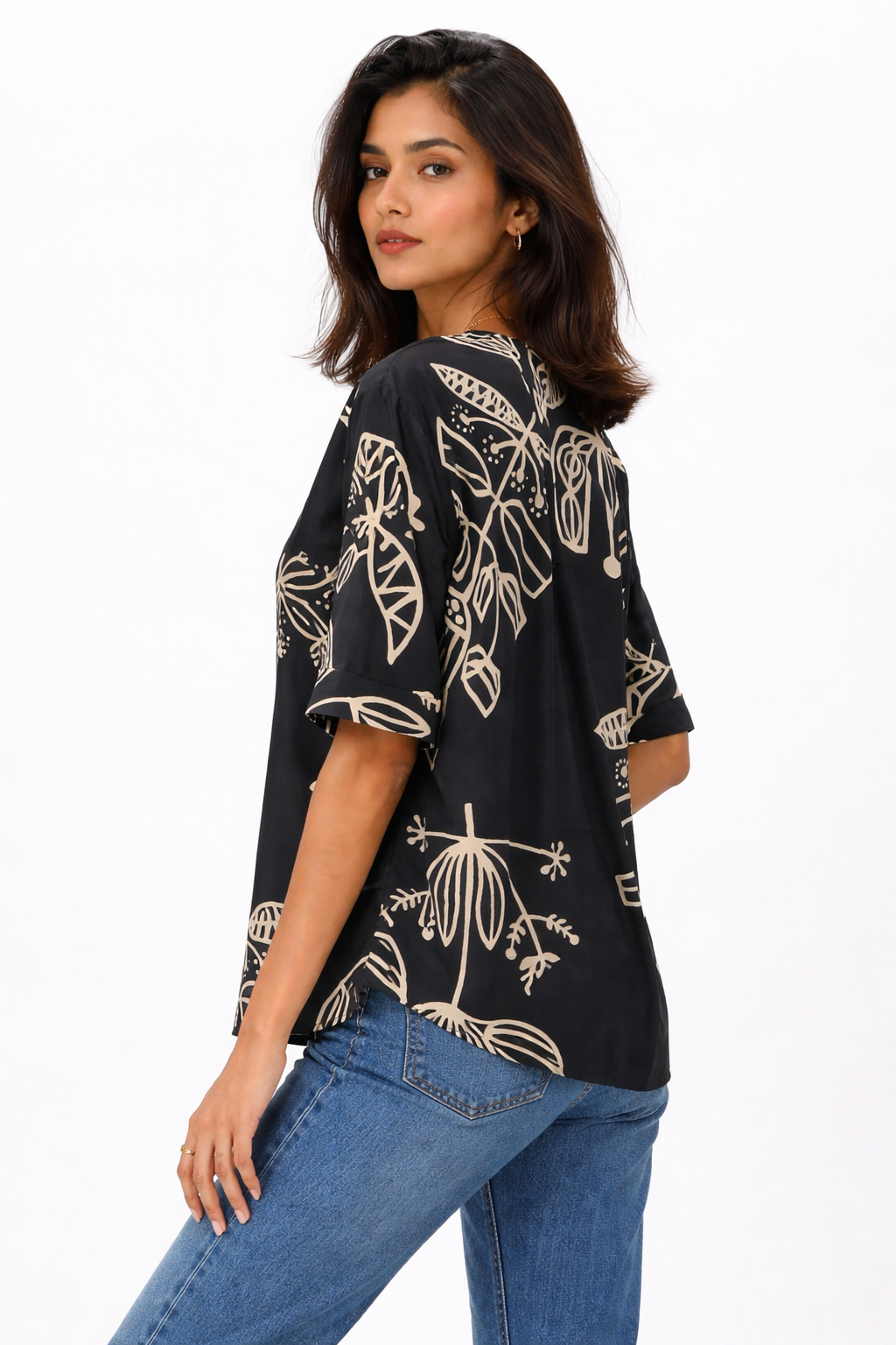 Top featuring a V-neckline and short sleeves. Designed with a relaxed silhouette and finished with a contrasting all-over abstract print